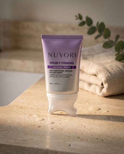 NUVORI gua sha cream on a travertine bathroom counter